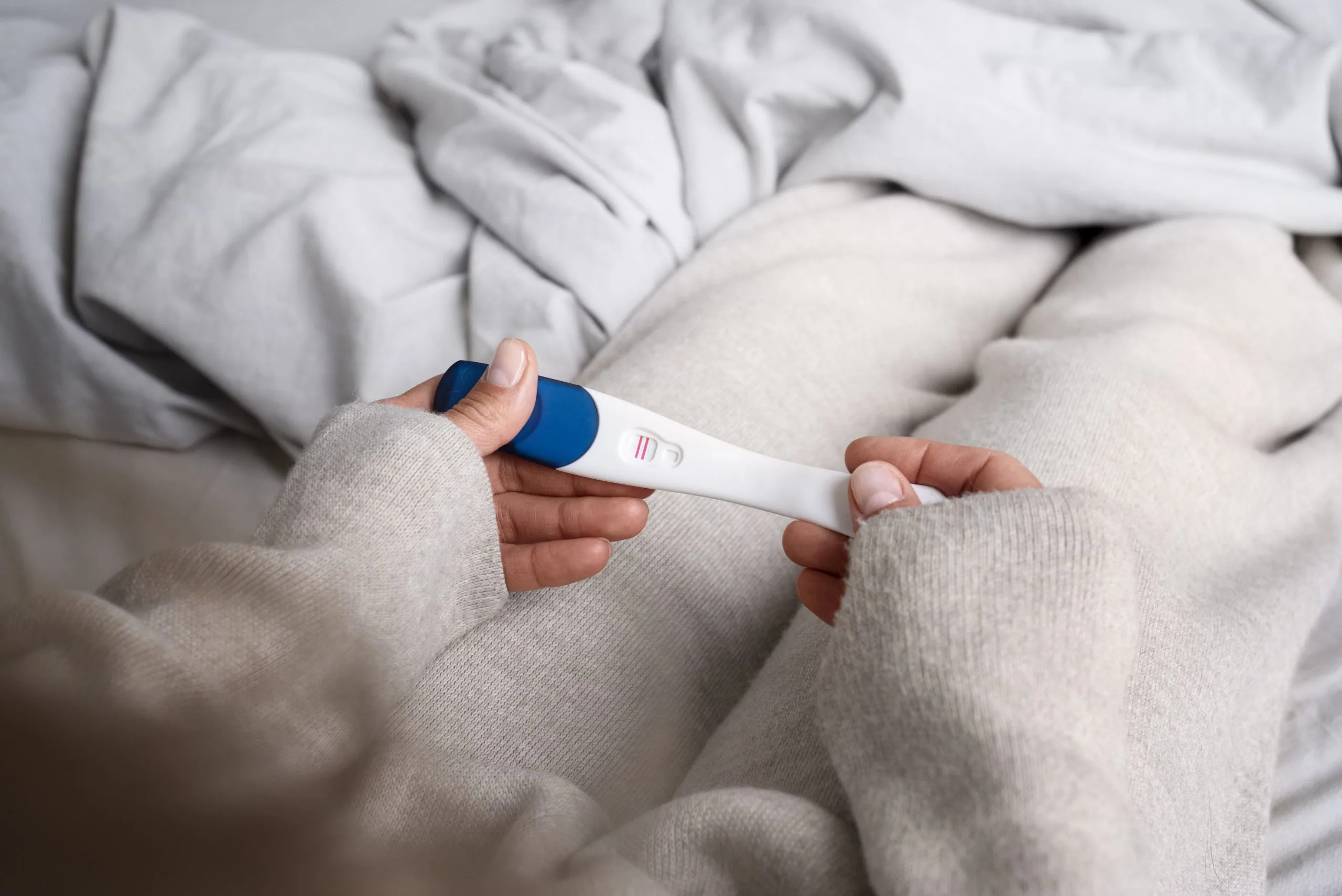 A woman holding a positive pregnancy test.