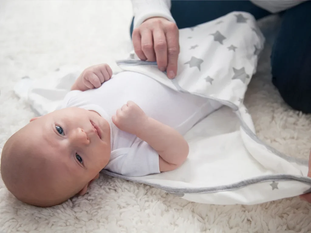 Wear a full-length bodysuit for a baby under a swaddle in winter