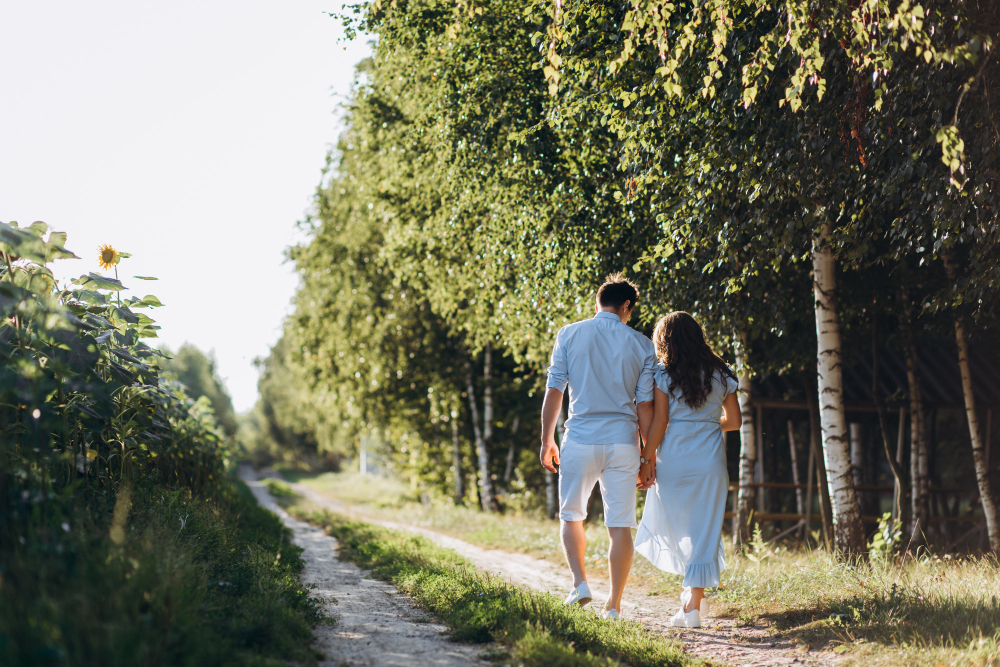 A couple walking together in a park, relaxed and smiling, during their trying-to-conceive journe