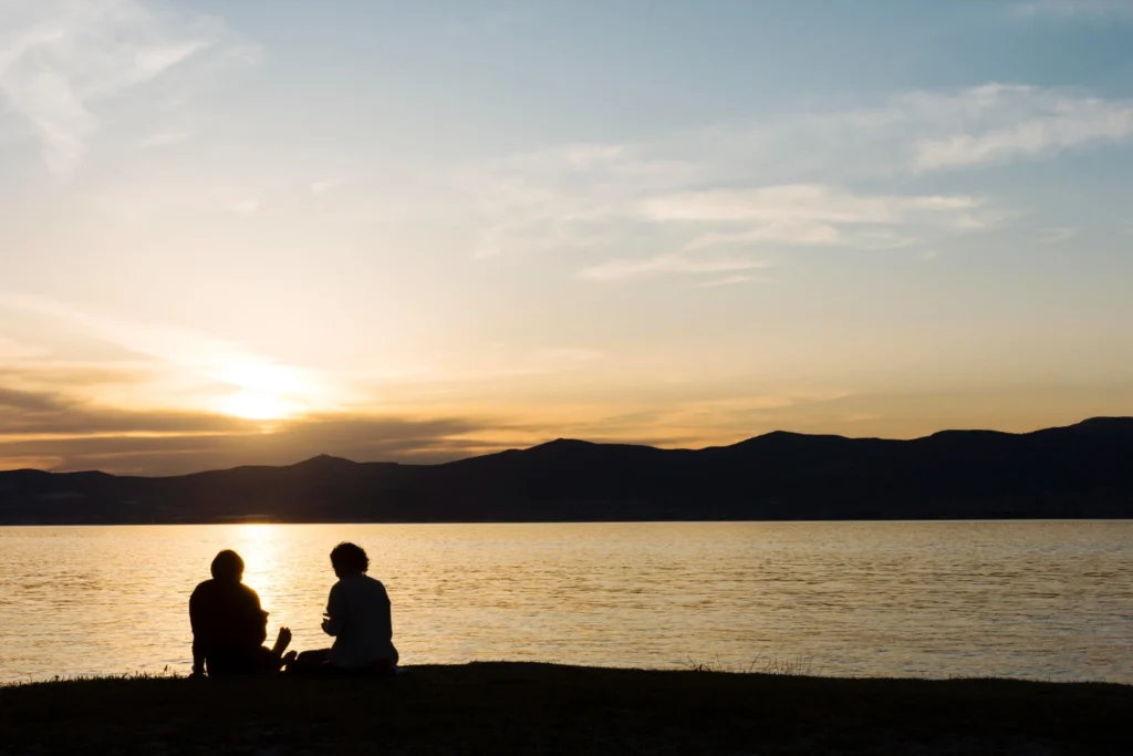 Warm photo of a couple sitting together, relaxed and at ease - conveying teamwork, calm, and optimism